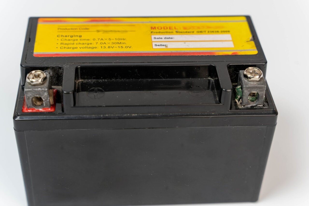 Batterie de moto reliée à un chargeur dans un garage.
