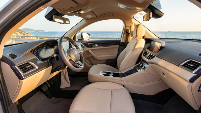 Habitacle moderne de voiture équipé de protections durables, éclairé par le soleil méditerranéen avec la mer de la Côte d’Azur visible par les fenêtres.