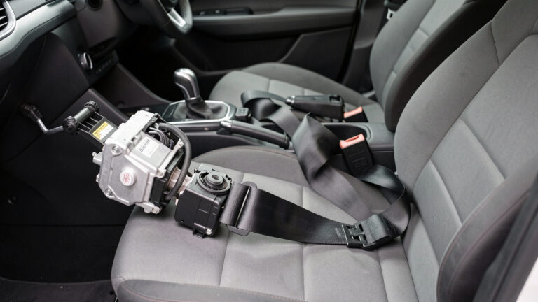 Vue détaillée de l’airbag du volant et de la ceinture de sécurité d’une voiture dans un atelier, avant le remplacement d’une pièce.